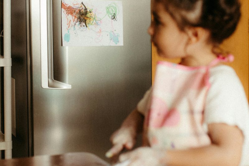 A family sitting together at dinner, a tablet lying on the kitchen counter
