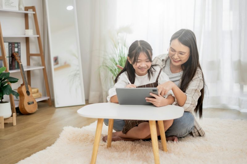 A parent and a child looking at a tablet together and deciding about an app